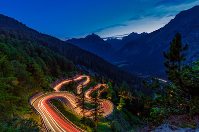 Aerial view of light trails by road against sky