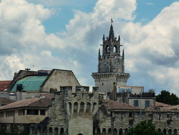 Low angle view of buildings against cloudy sky