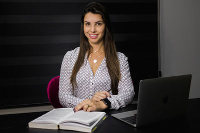 Portrait of a smiling young woman using mobile phone