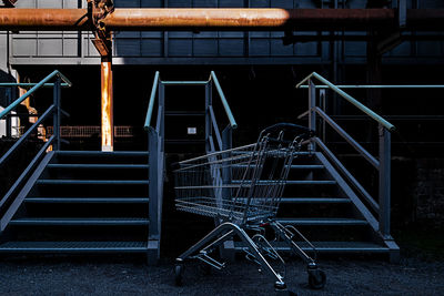 Shopping cart in front of staircase in industrial plant