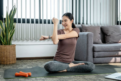 Young woman sitting on sofa at home