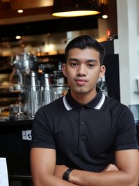 Portrait of young man standing in cafe