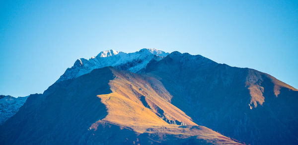 Low angle view of mountains against clear blue sky