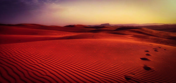 Scenic view of desert against sky during sunset