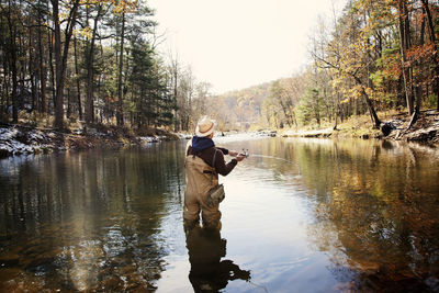 Rear view of man fishing in lake