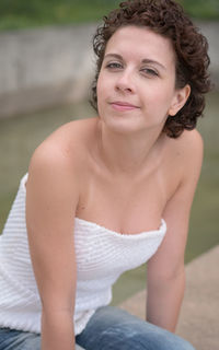 Portrait of smiling young woman sitting outdoors