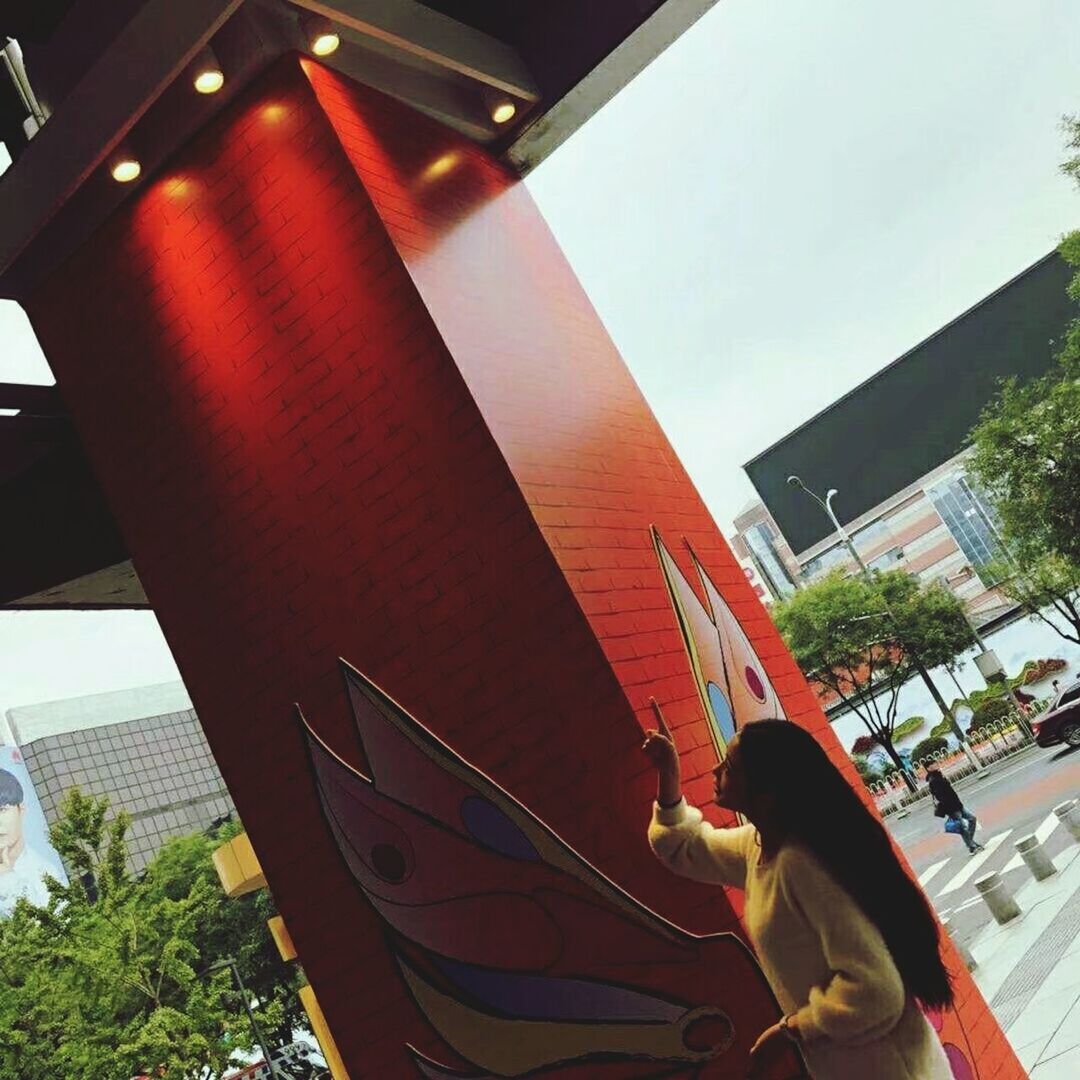 LOW ANGLE VIEW OF WOMAN WITH UMBRELLA AGAINST SKY