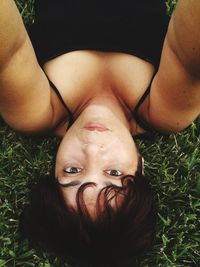 Portrait of woman lying down on grassy field