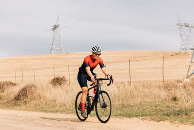 Woman cycling on dirt road