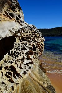 Rock formation in sea against clear sky
