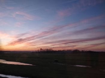 Scenic view of field against sky during sunset