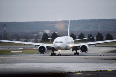 Airplane on runway against sky