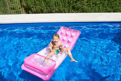 Boy bathing in a pool on a sunny summer day.