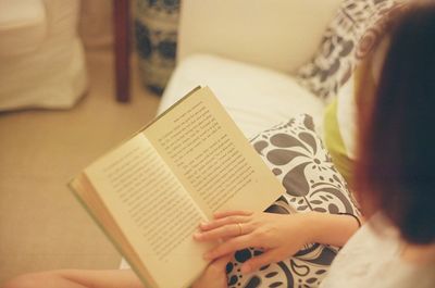 High angle view of woman reading book at home