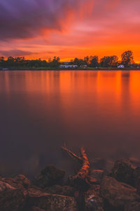 Scenic view of lake against orange sky