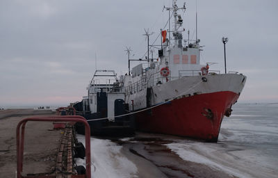 Fishing boat in sea against sky during winter