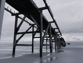 Black and white monochrome abandoned pier on the beach