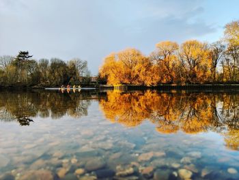 Reflection of trees in river against sky during autumn