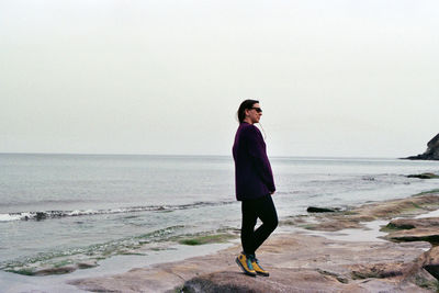 Full length of man standing on beach against clear sky