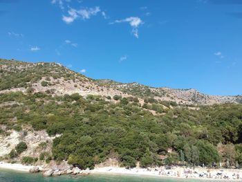 Scenic view of sea and mountains against blue sky