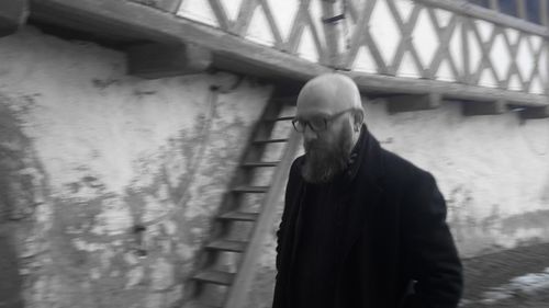 Man standing on bridge against wall