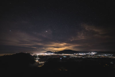 Scenic view of illuminated mountains against sky at night