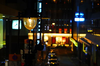 Illuminated lights on street by buildings at night