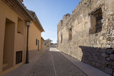 Footpath amidst buildings against sky