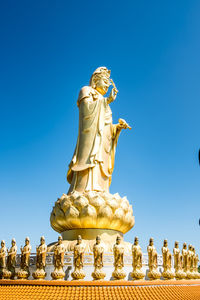 Low angle view of statue against blue sky