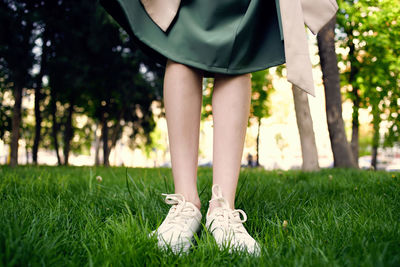 Low section of woman standing on field