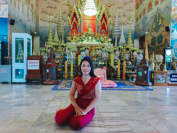 Portrait of woman sitting on floor at temple