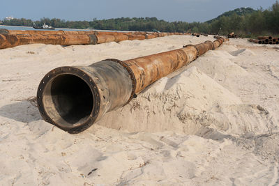 Old rusty pipe on sand