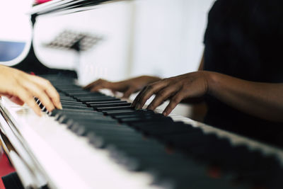 Close-up of hands playing piano