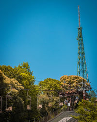 Low angle view of communications tower against clear blue sky