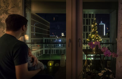 Rear view of man and woman in glass window at night