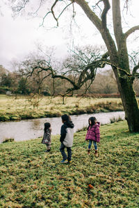 Rear view of women walking on field