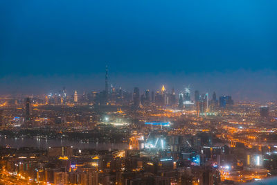 Illuminated buildings in city against sky at night