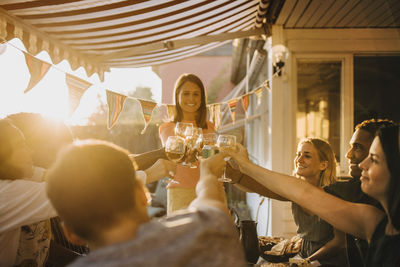 Happy multi-ethnic friends toasting wineglasses while enjoying at dinner party