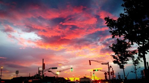 Low angle view of traffic lights against cloudy sunset