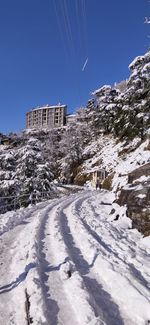 Snow covered buildings against clear blue sky