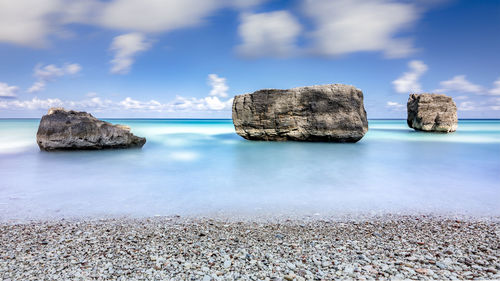 Rocks on sea shore against sky