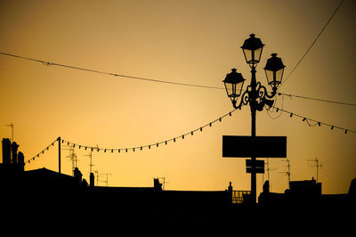 Low angle view of silhouette lamp post against sky during sunset