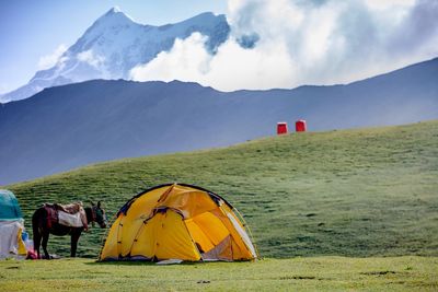 Tent on field against mountain range