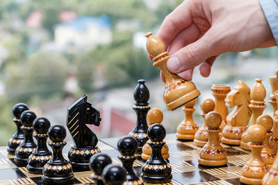 Close-up of hand holding chess pieces