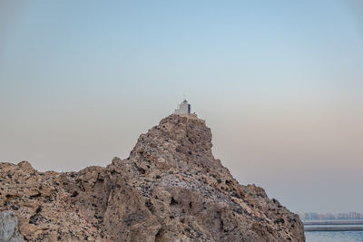 Church on cliff against sky during sunset