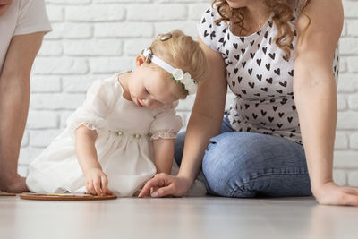 Midsection of parents playing with deaf daughter at home