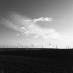 Scenic view of field against sky, windmills