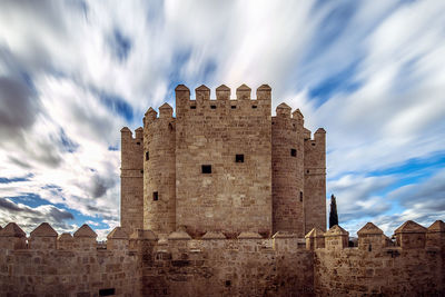 Low angle view of historic building against cloudy sky