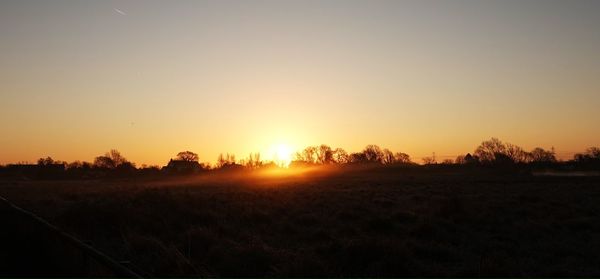 Scenic view of field against sky during sunset