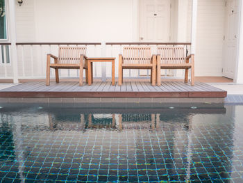 Empty chairs by swimming pool